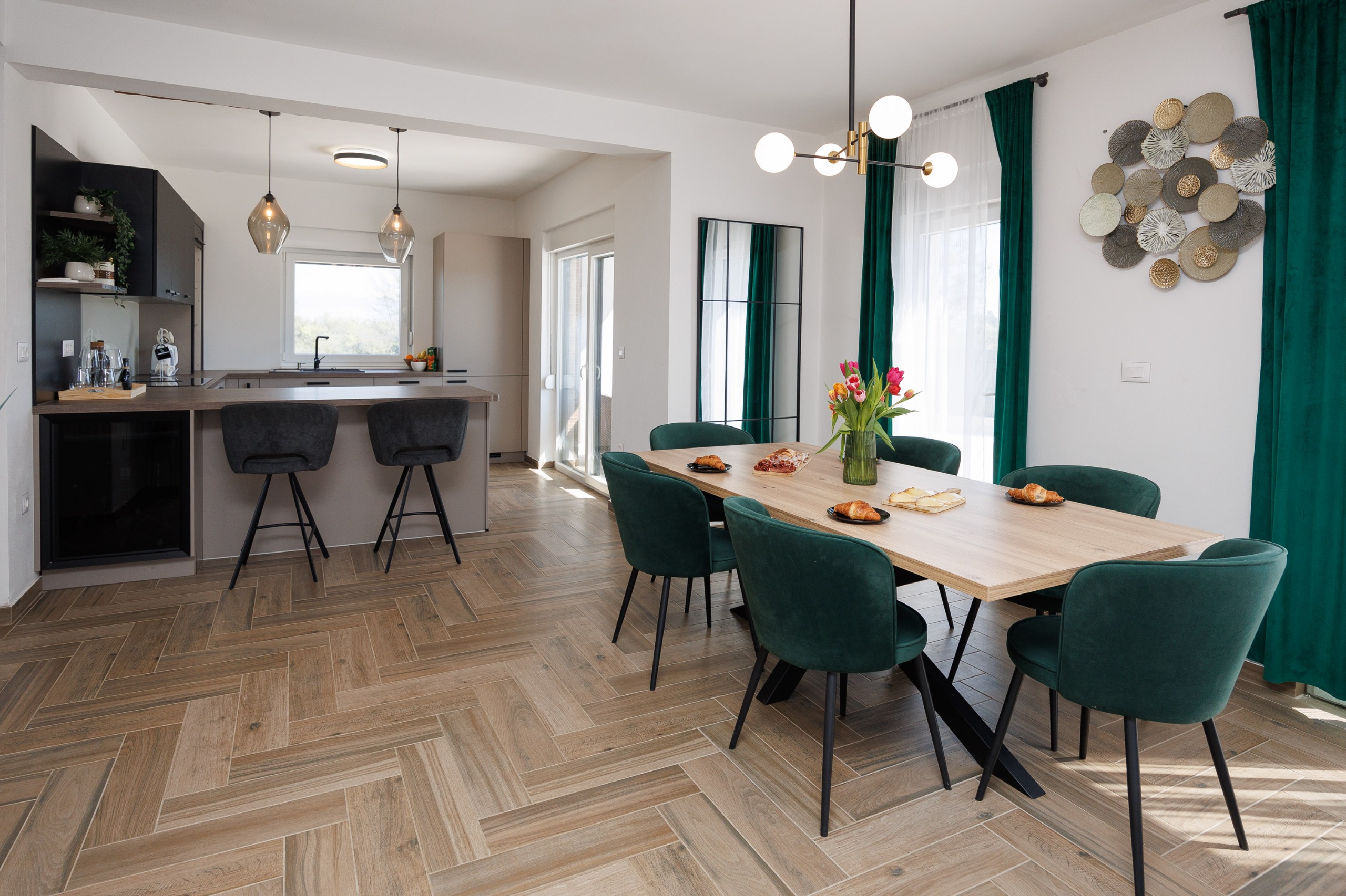 Dining area with emerald chairs