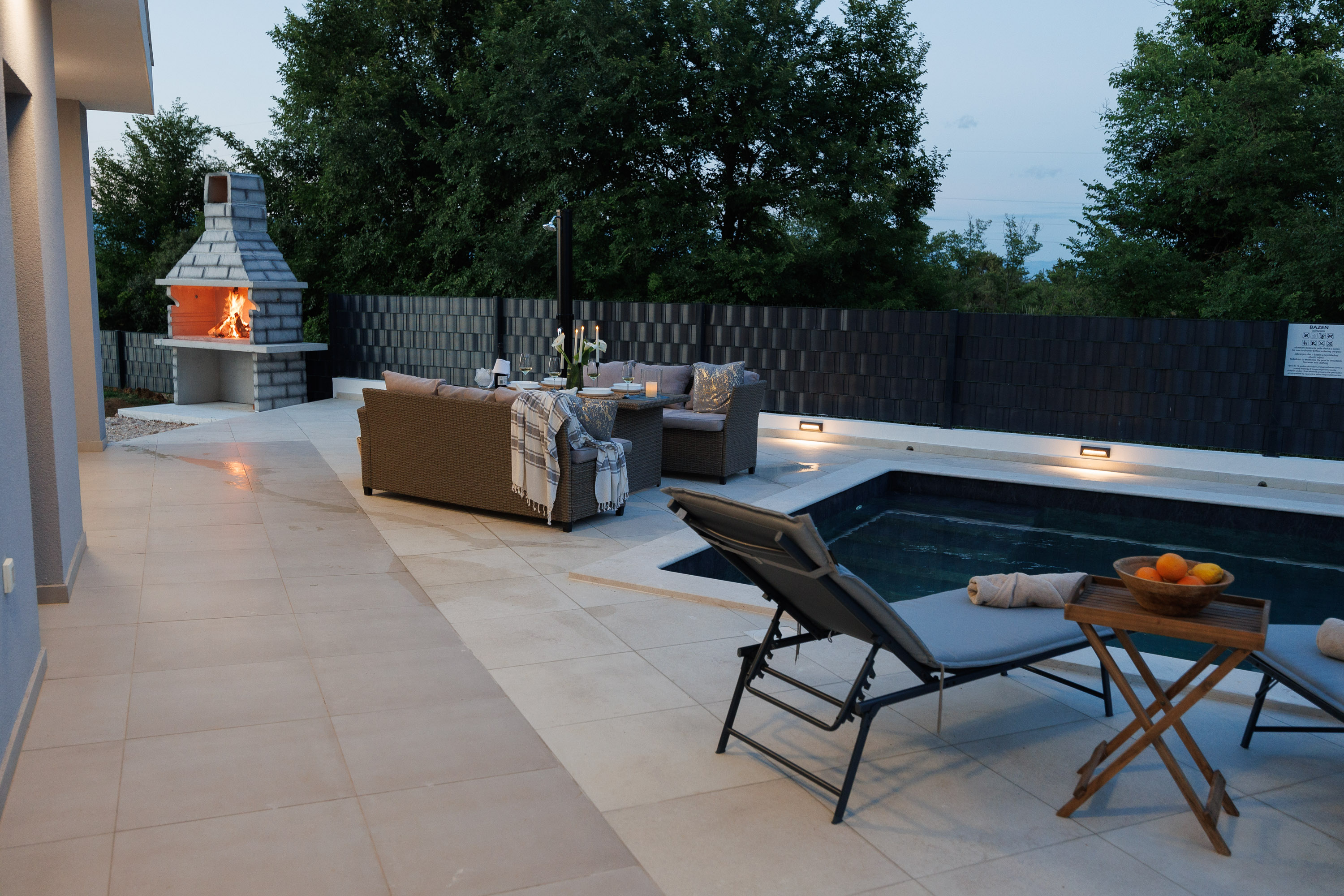 Outdoor fireplace lit at dusk
