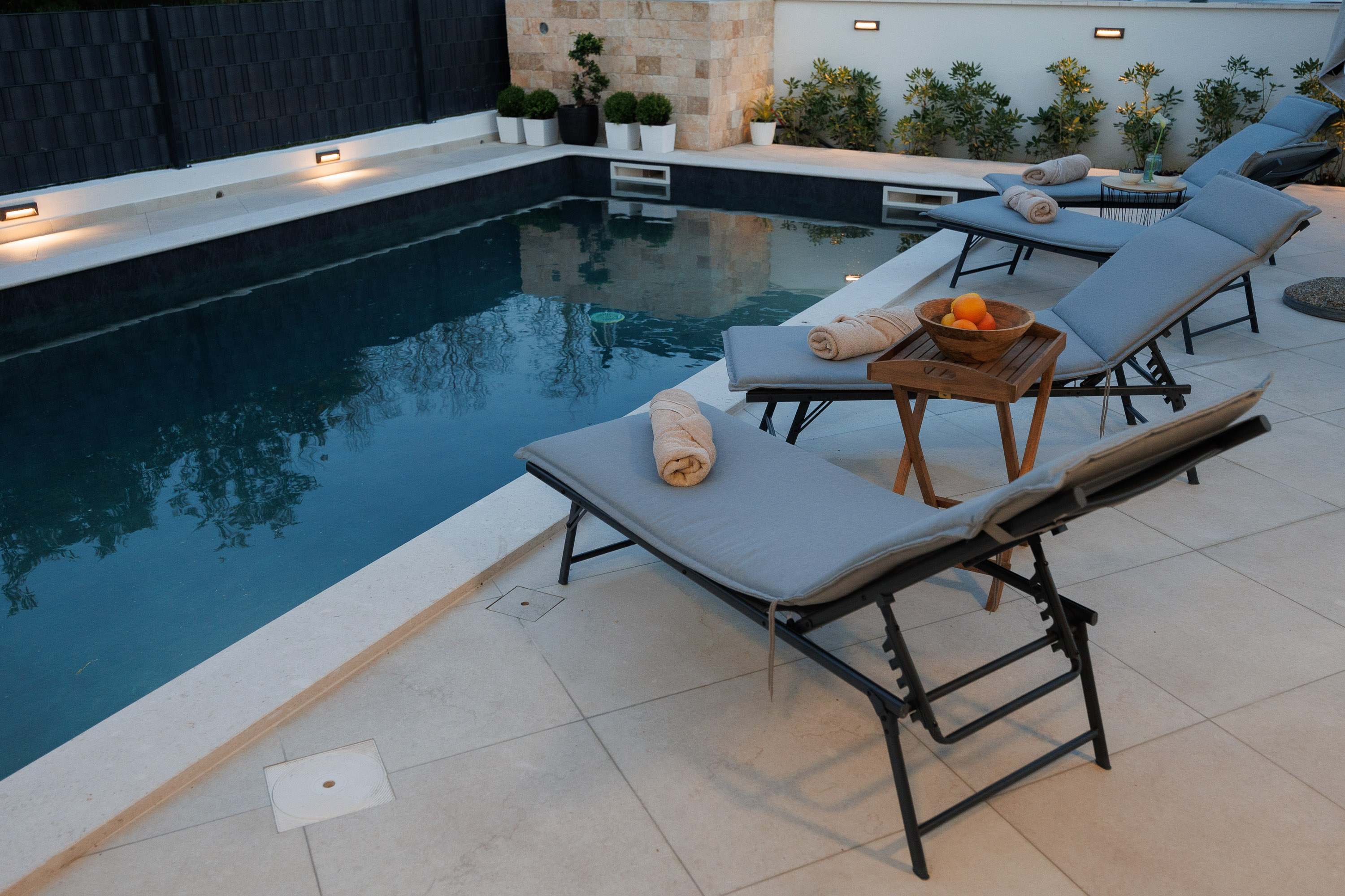 Pool loungers at dusk